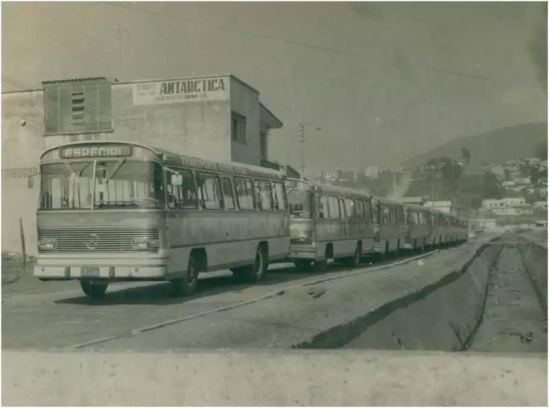 Foto 133: Avenida João Pinheiro : [Ônibus da] Transportes Cisne Ltda. : [vista panorâmica da cidade] : Itabira (MG)