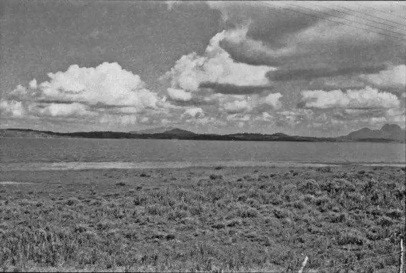 Foto 33: Lagoa de Emboacica, próxima ao limite com Macaé. Nota-se ao fundo as serras, ao redor da lagoa pequenas ondulações (RJ)
